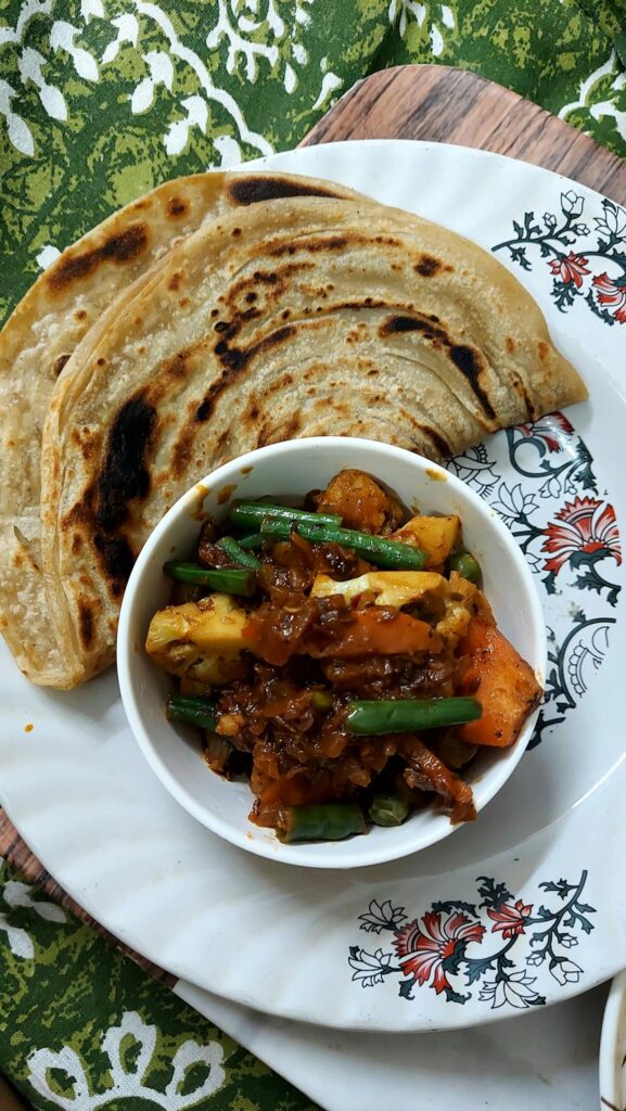 Savory Indian roti served with colorful mixed vegetable curry in a decorative setting.